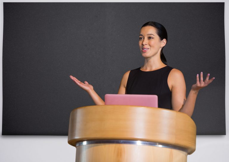 digital composite of businesswoman on podium speaking at conference with board
